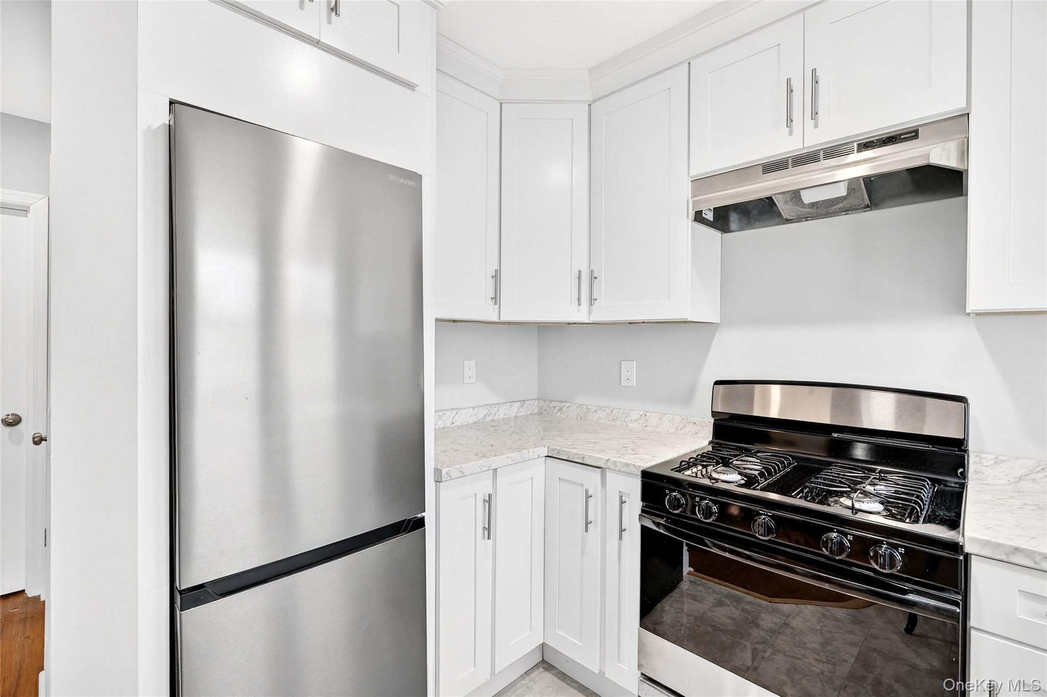 669 North Division Street Peekskill, NY 10566 - Photo 25 of 48 a kitchen with stainless steel appliances and white cabinets
