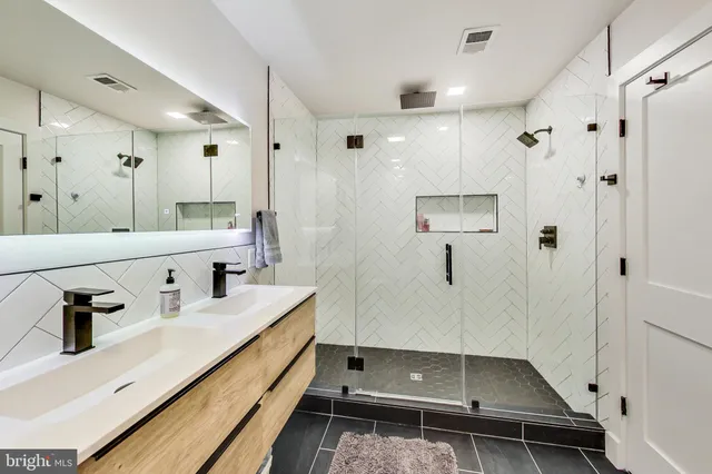 a bathroom with double vanity and mirrors