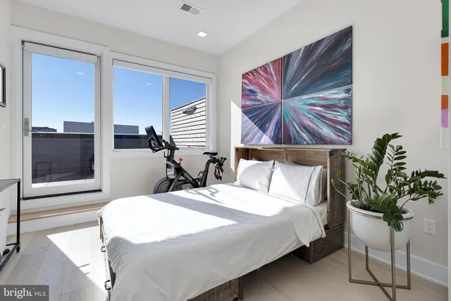 a bedroom with a large bed and a potted plant