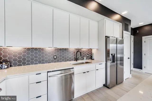 a kitchen with stainless steel appliances granite countertop a refrigerator and a stove