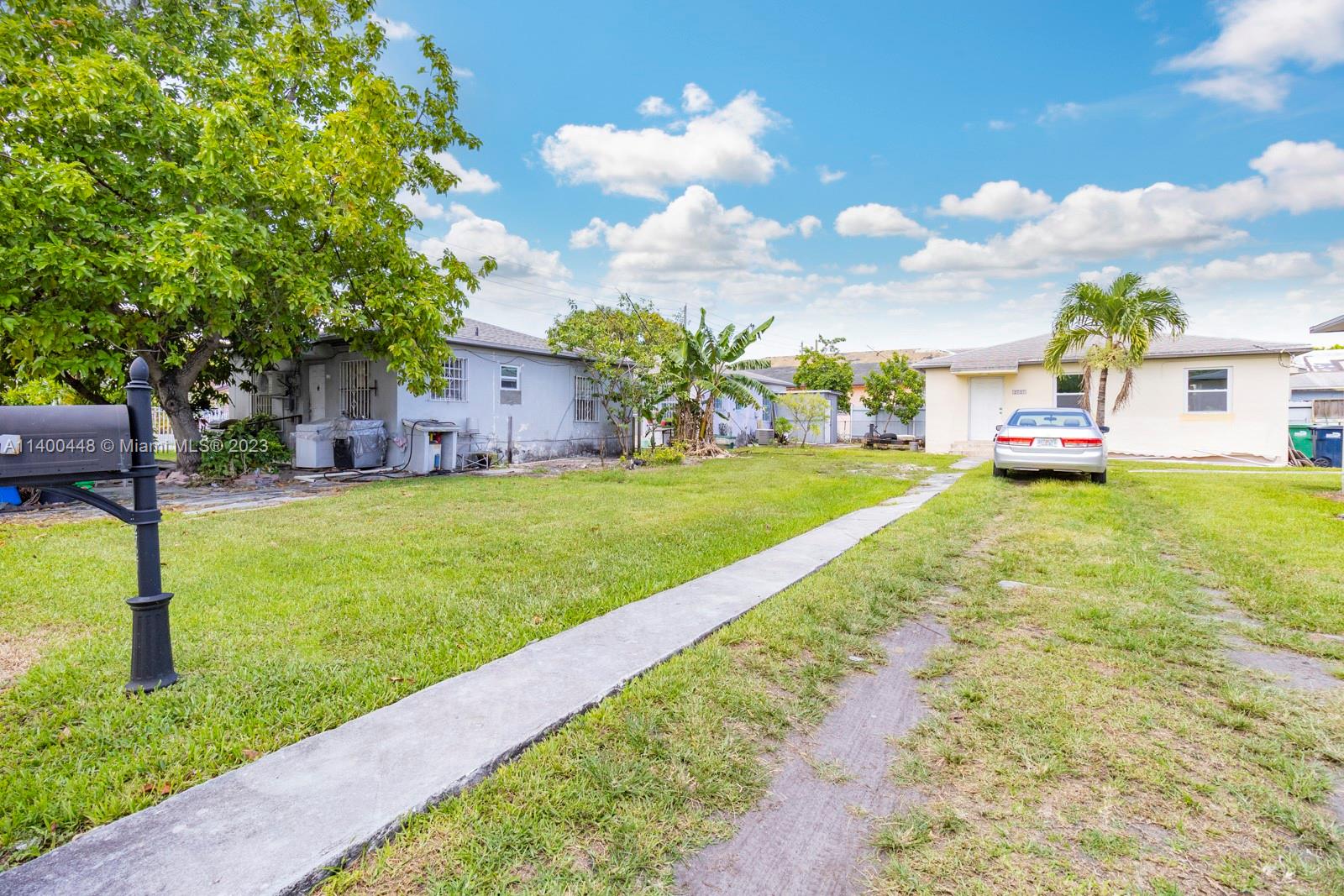 2990 Northwest 28th Street Miami, FL 33142 - Photo 3 of 13 a view of a house with a big yard potted plants and large tree