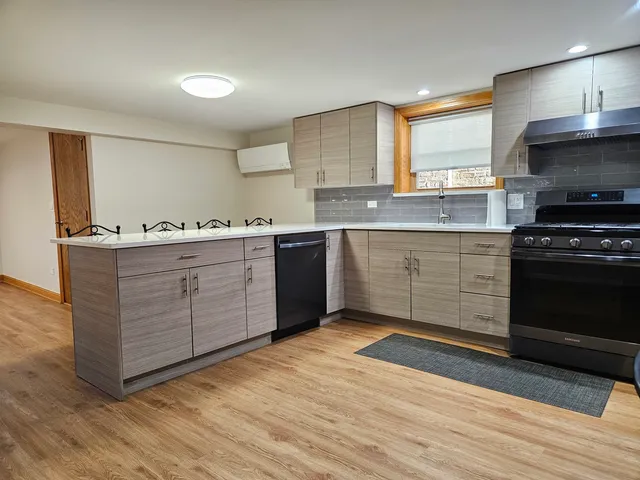 a kitchen with stainless steel appliances granite countertop a stove a sink and a refrigerator