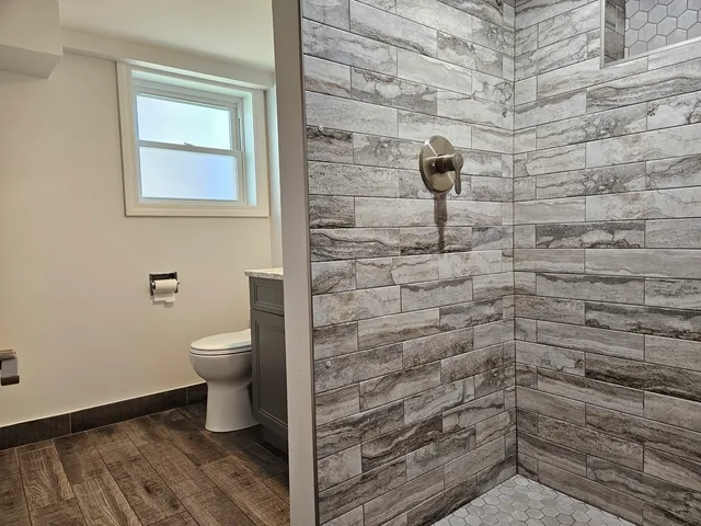 a bathroom with a toilet and a shower