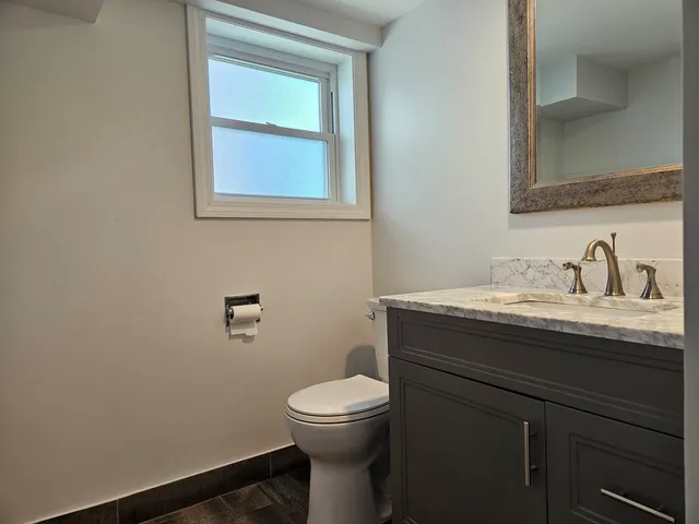 a bathroom with a toilet a sink and mirror