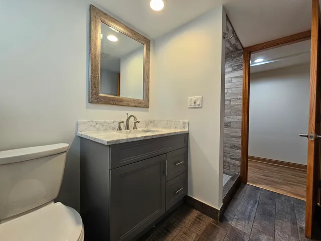 a bathroom with a sink a toilet and shower