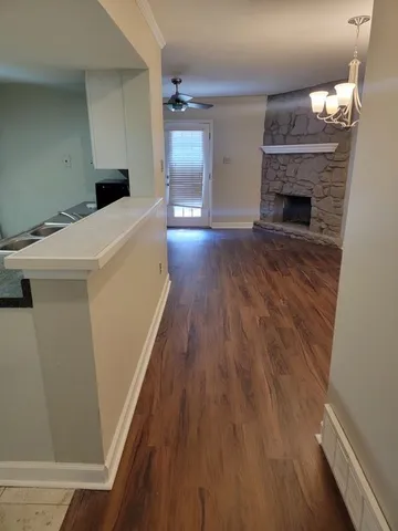 a hallway view with fireplace a wooden floor and a fireplace