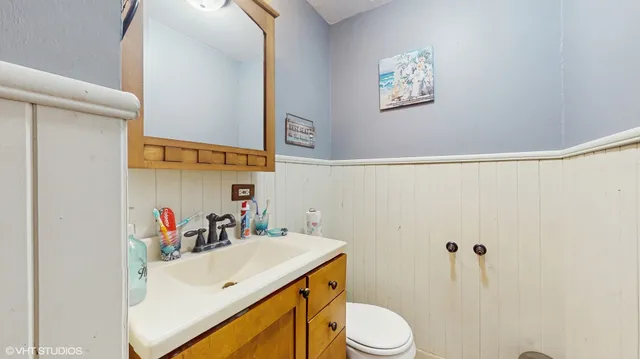a bathroom with a sink vanity mirror and toilet