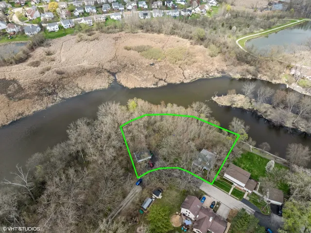 an aerial view of a house with a yard and mountain view in back