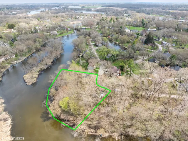 an aerial view of a house with a yard and lake view