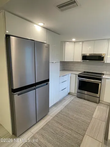 a kitchen with stainless steel appliances a refrigerator sink and cabinets