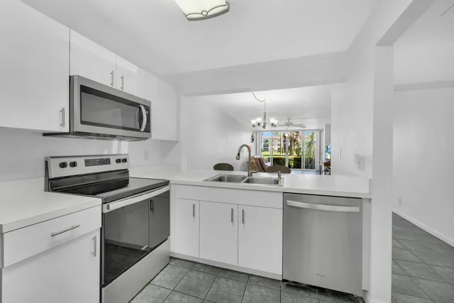 a kitchen with white cabinets appliances and sink