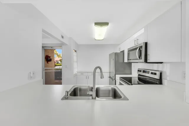 a kitchen with kitchen island a sink and a stove top oven with wooden floor