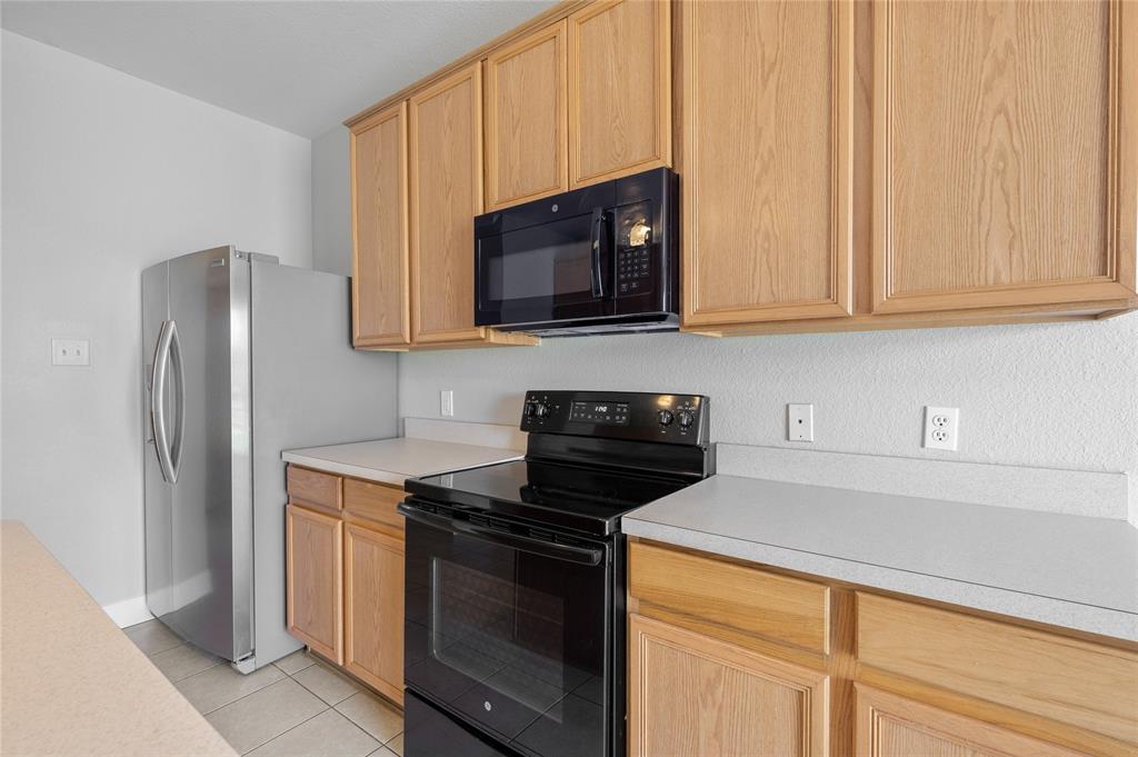 1514 Hanover Lane Van Alstyne, TX 75495 - Photo 20 of 39 a kitchen with stainless steel appliances granite countertop a stove a microwave and a refrigerator