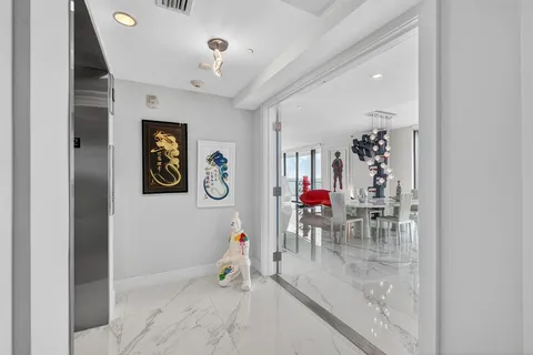 a view of a hallway with a dining area and chandelier