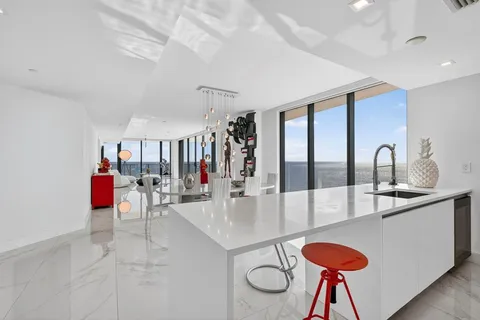 a kitchen with stainless steel appliances kitchen island a table and chairs in it
