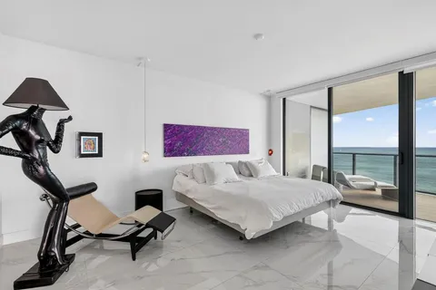 a bedroom with a bed a desk and chair with window