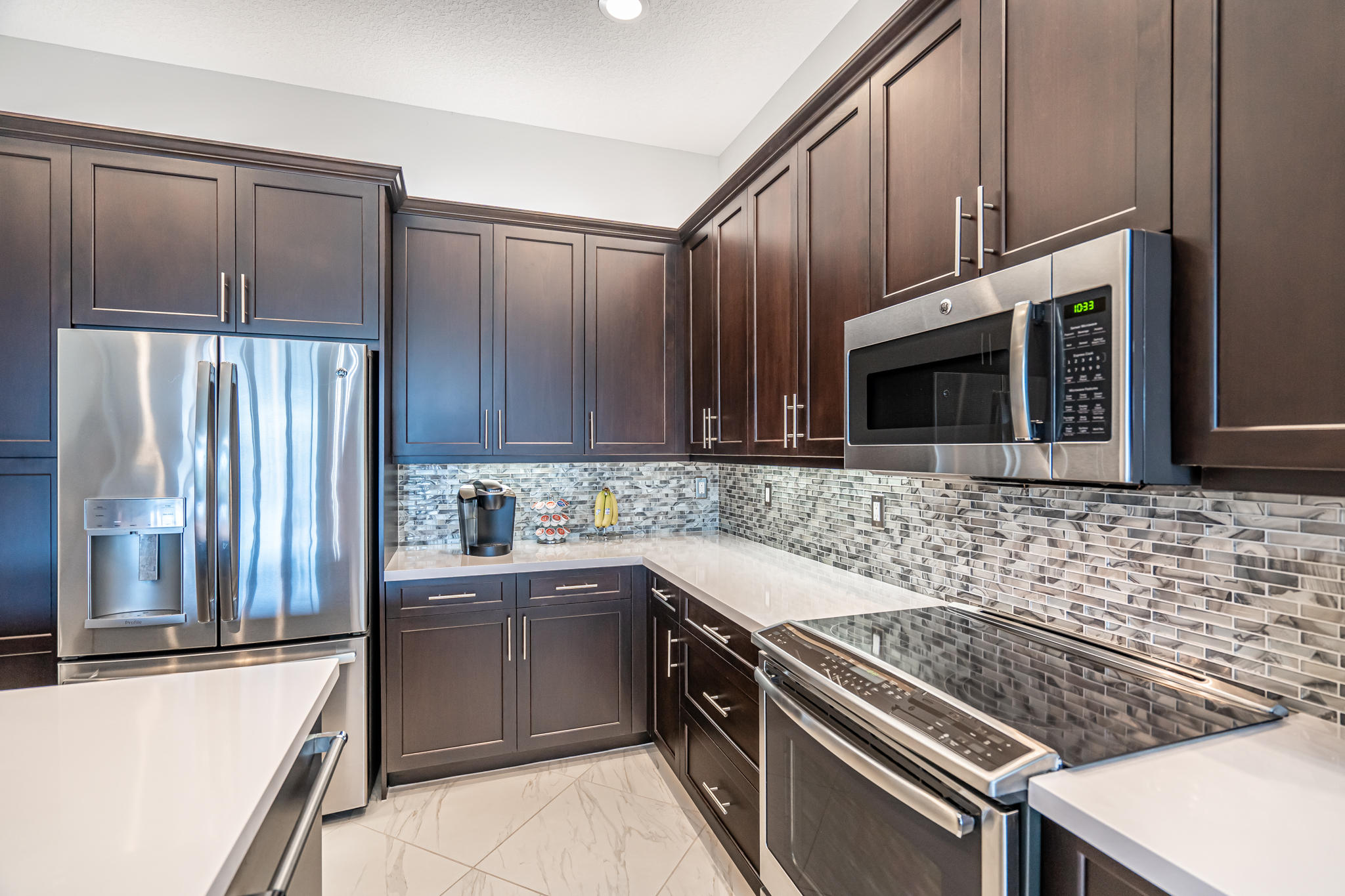 12591 Bonnington Range Drive Boynton Beach, FL 33473 - Photo 10 of 62 a kitchen with stainless steel appliances a stove a sink and a microwave