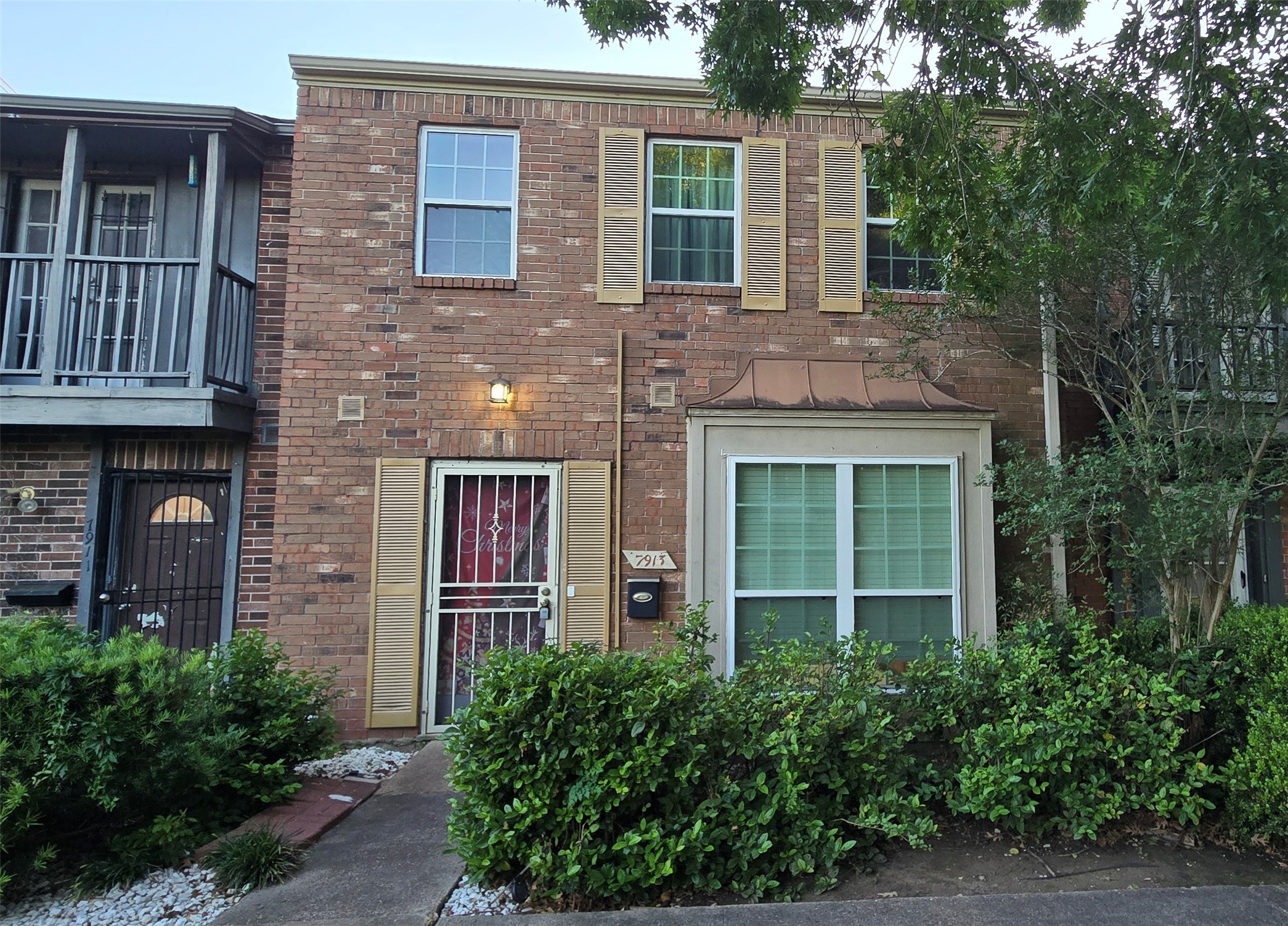 a view of a brick house with large windows and a large window