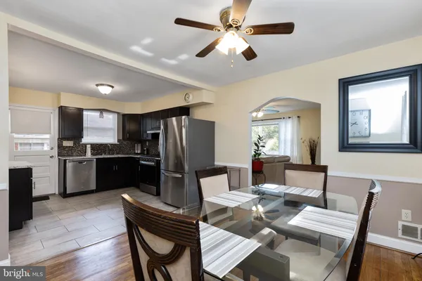 a kitchen with a refrigerator a dining table and chairs