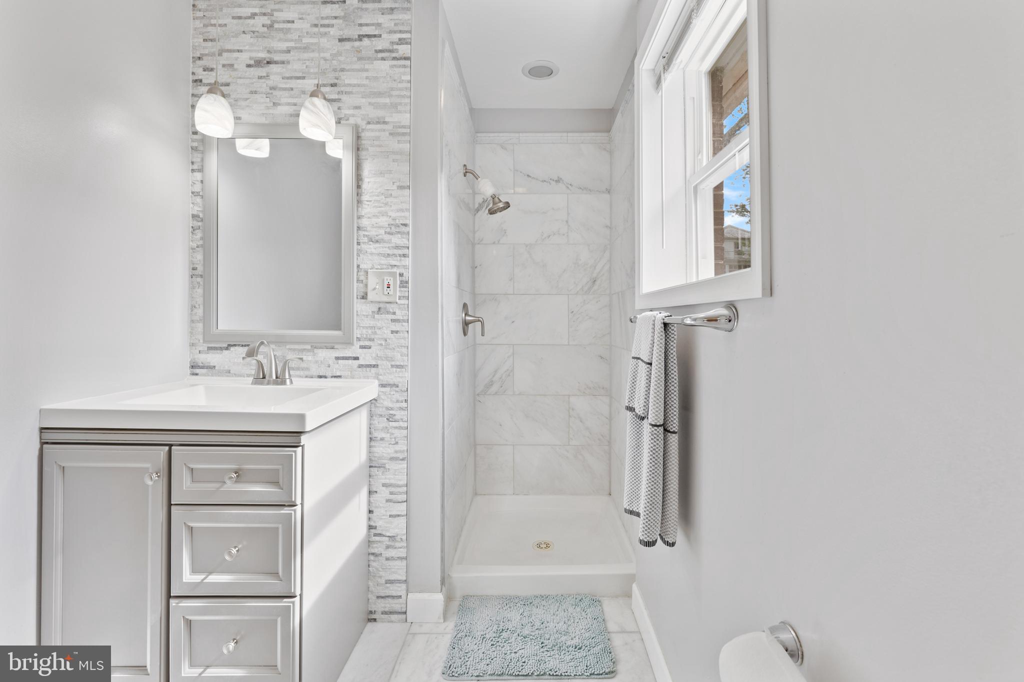 123 Walnut Street Northwest Washington, DC 20012 - Photo 13 of 38 a bathroom with a shower a sink and a mirror