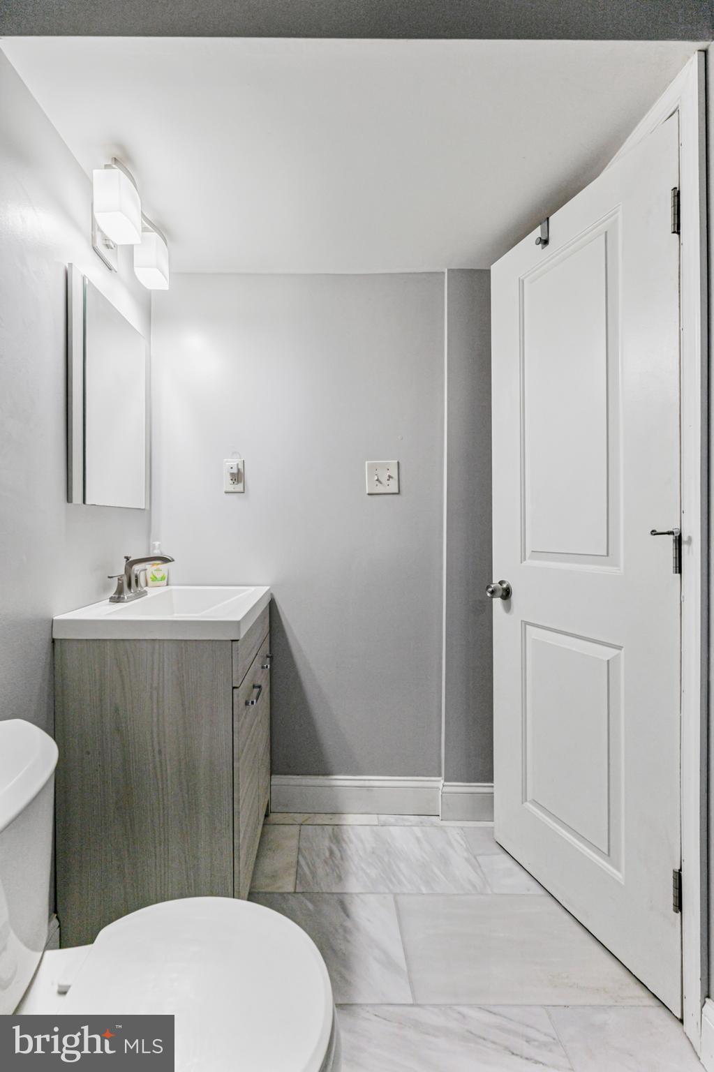 123 Walnut Street Northwest Washington, DC 20012 - Photo 23 of 38 a bathroom with a sink a toilet a mirror and vanity