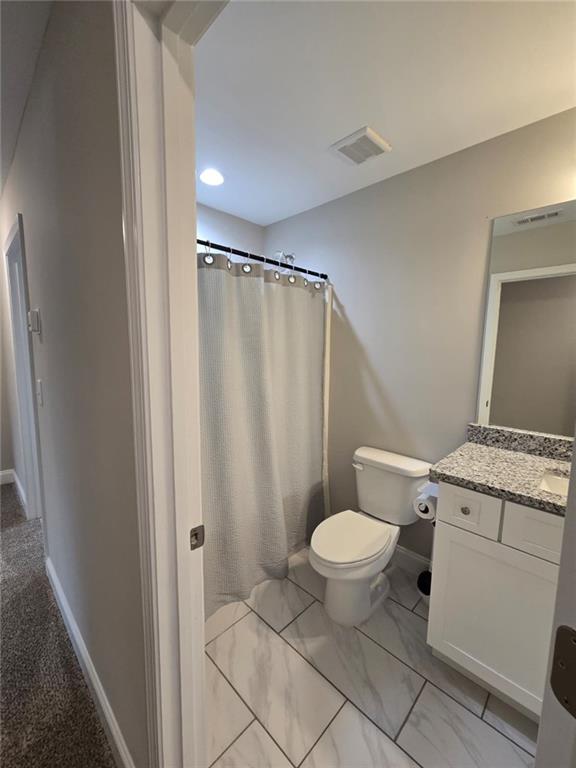 2197 Holders Siding Road Jefferson, GA 30549 - Photo 9 of 29 a bathroom with a granite countertop toilet and a shower