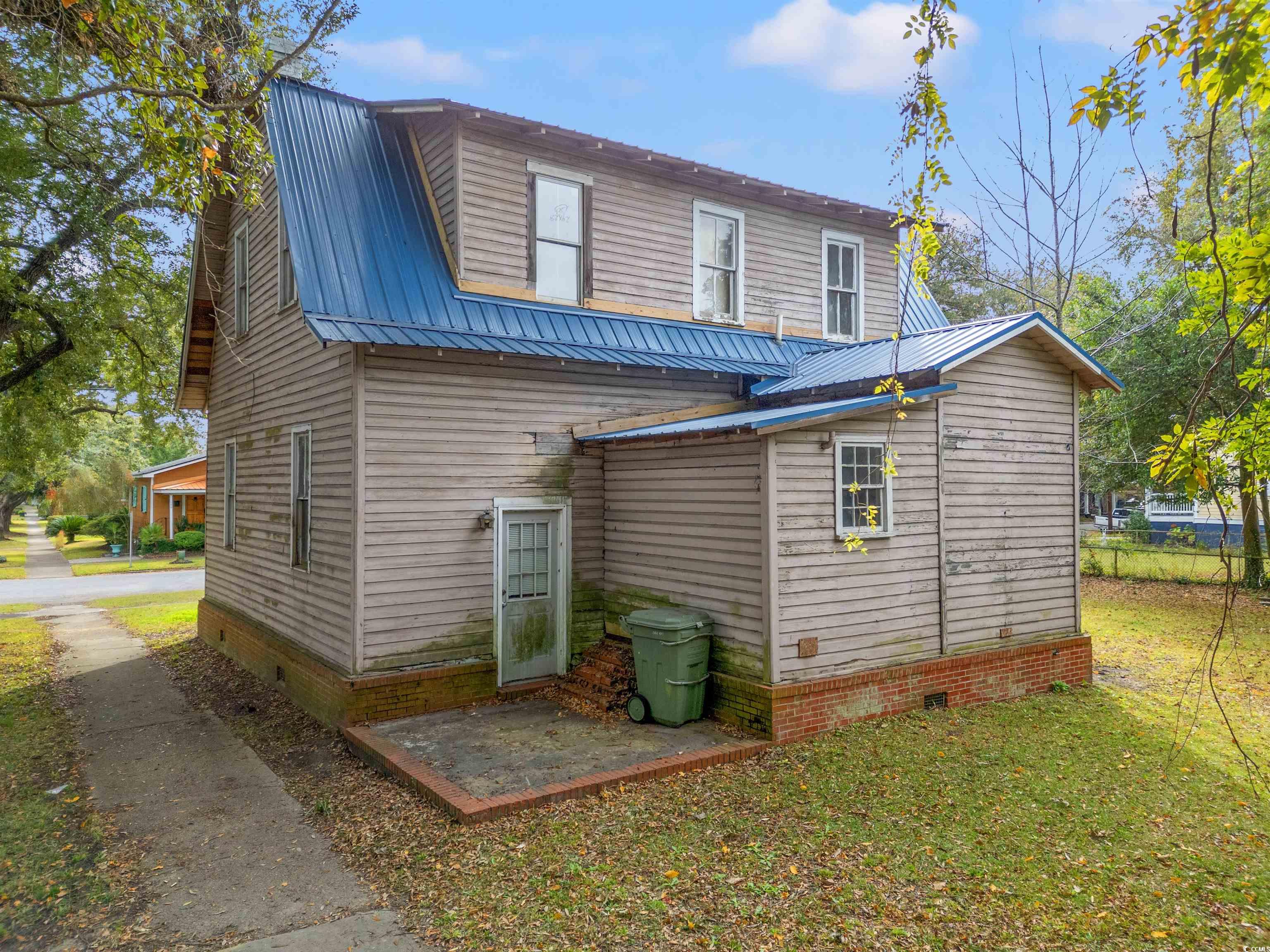 133 Wood Street Georgetown, SC 29440 - Photo 20 of 37 Back of property featuring crawl space, a metal roof, and a lawn