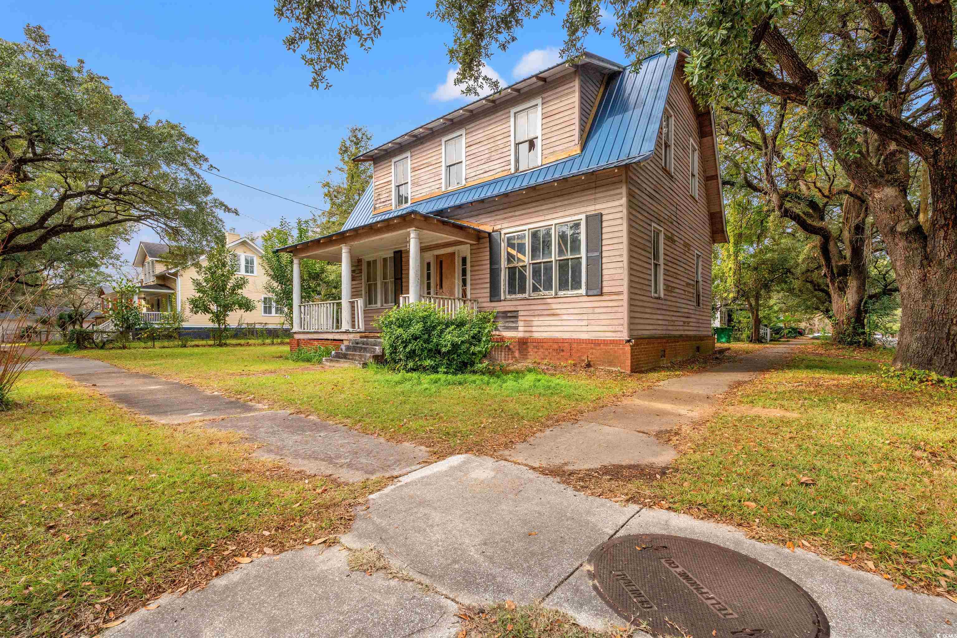 133 Wood Street Georgetown, SC 29440 - Photo 2 of 37 View of front facade with a front yard, a metal roof, covered porch, and a gambrel roof
