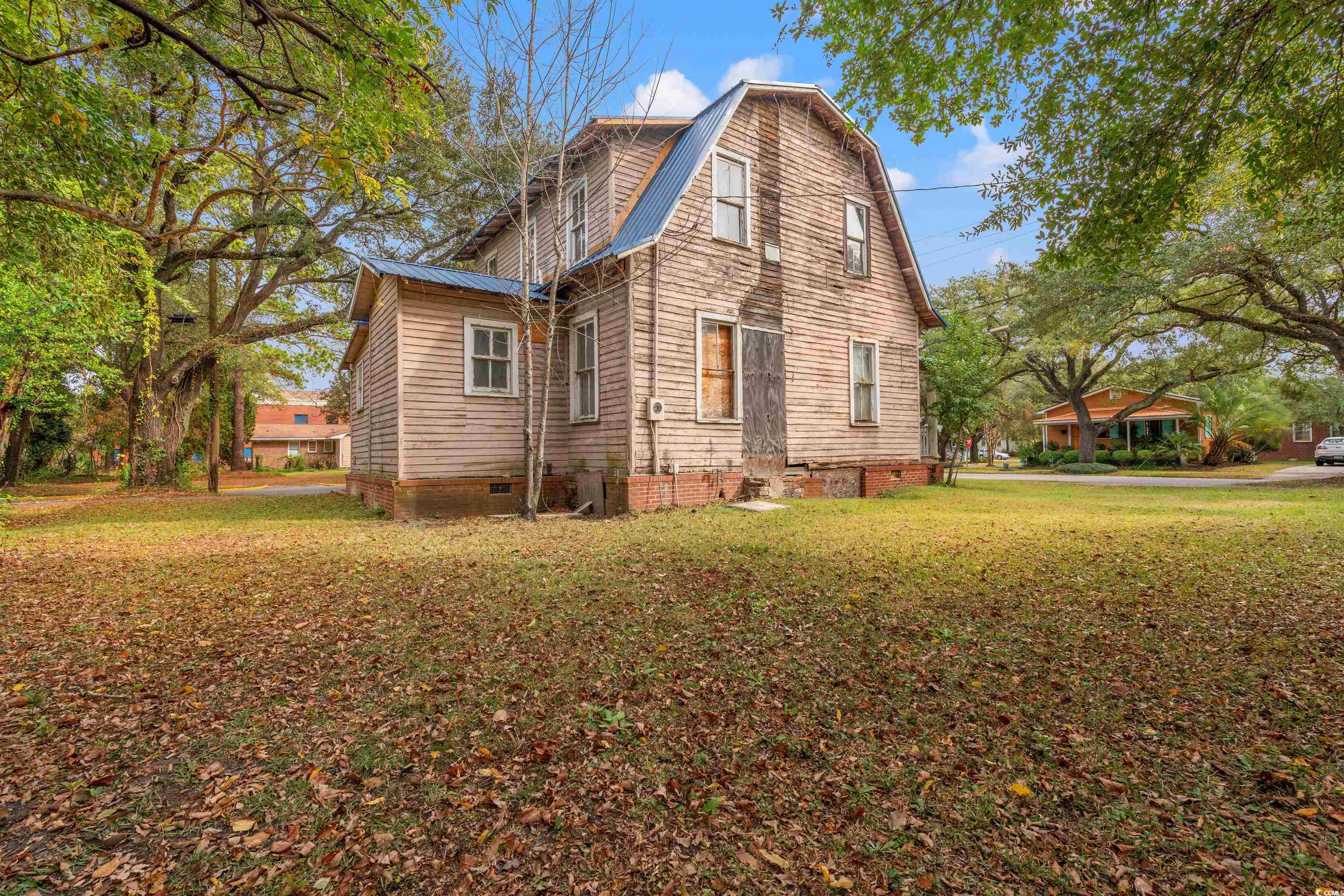 133 Wood Street Georgetown, SC 29440 - Photo 4 of 37 View of side of property with a metal roof, a gambrel roof, a lawn, and crawl space