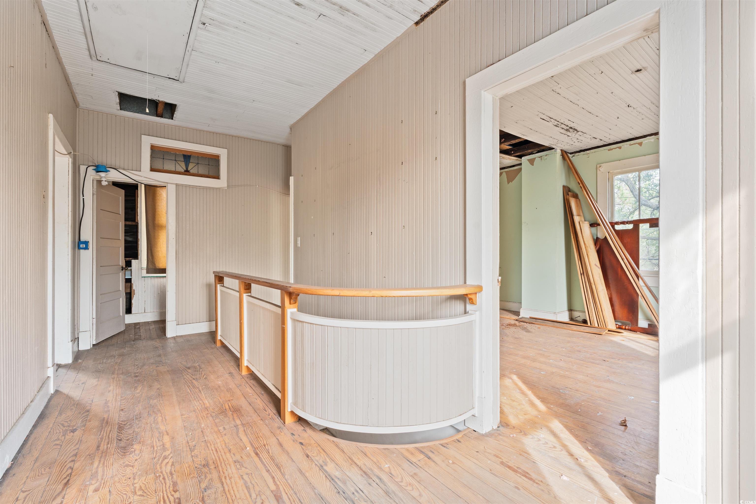 133 Wood Street Georgetown, SC 29440 - Photo 10 of 37 Hallway featuring light wood-style flooring, attic access, and wood walls