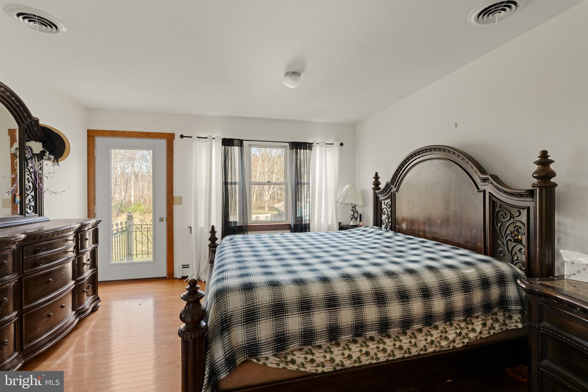 451 Pine Swamp Road Elverson, PA 19520 - Photo 14 of 91 a bedroom with a bed and a dresser with mirror