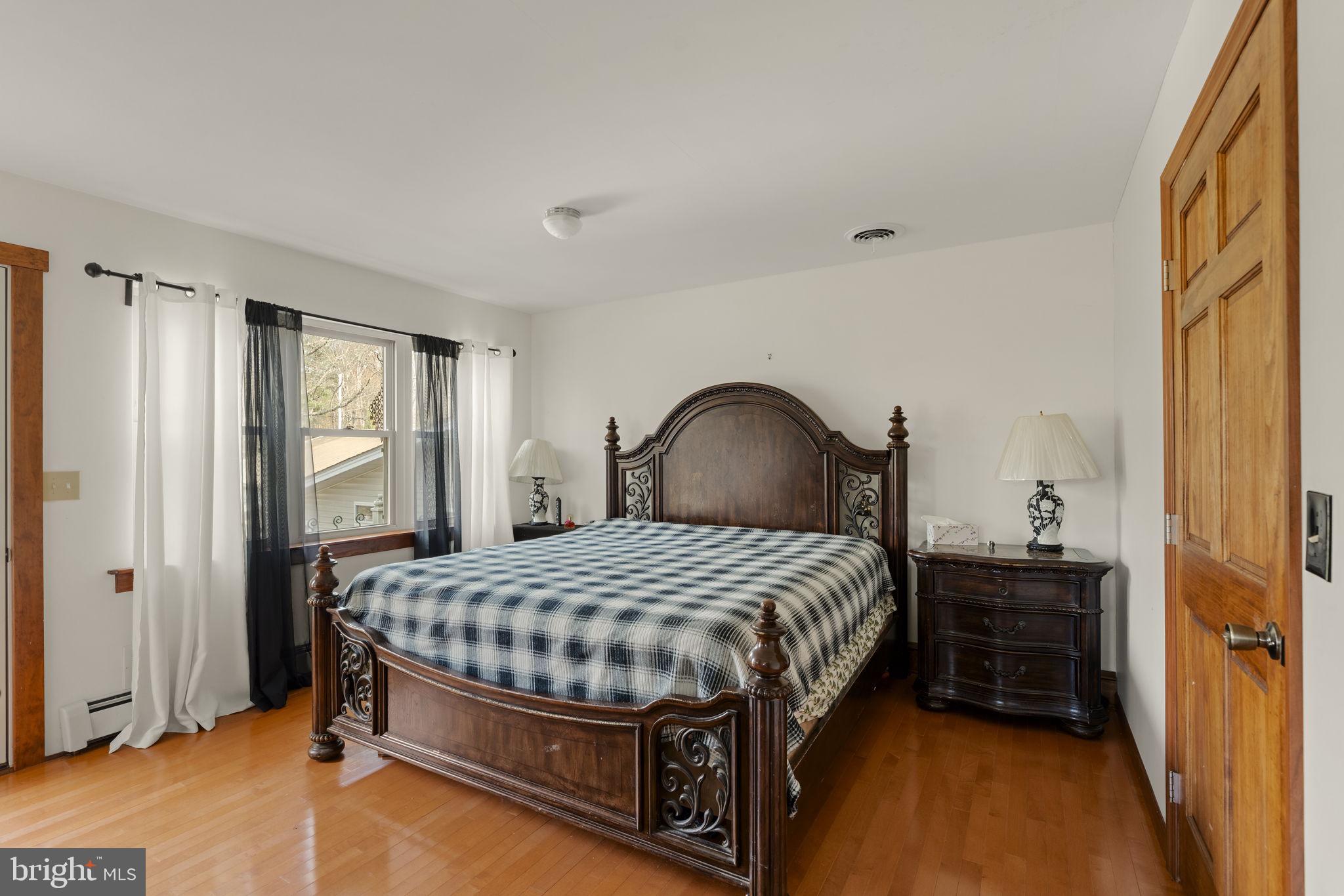 451 Pine Swamp Road Elverson, PA 19520 - Photo 15 of 91 a bedroom with a bed and a dresser next to a window