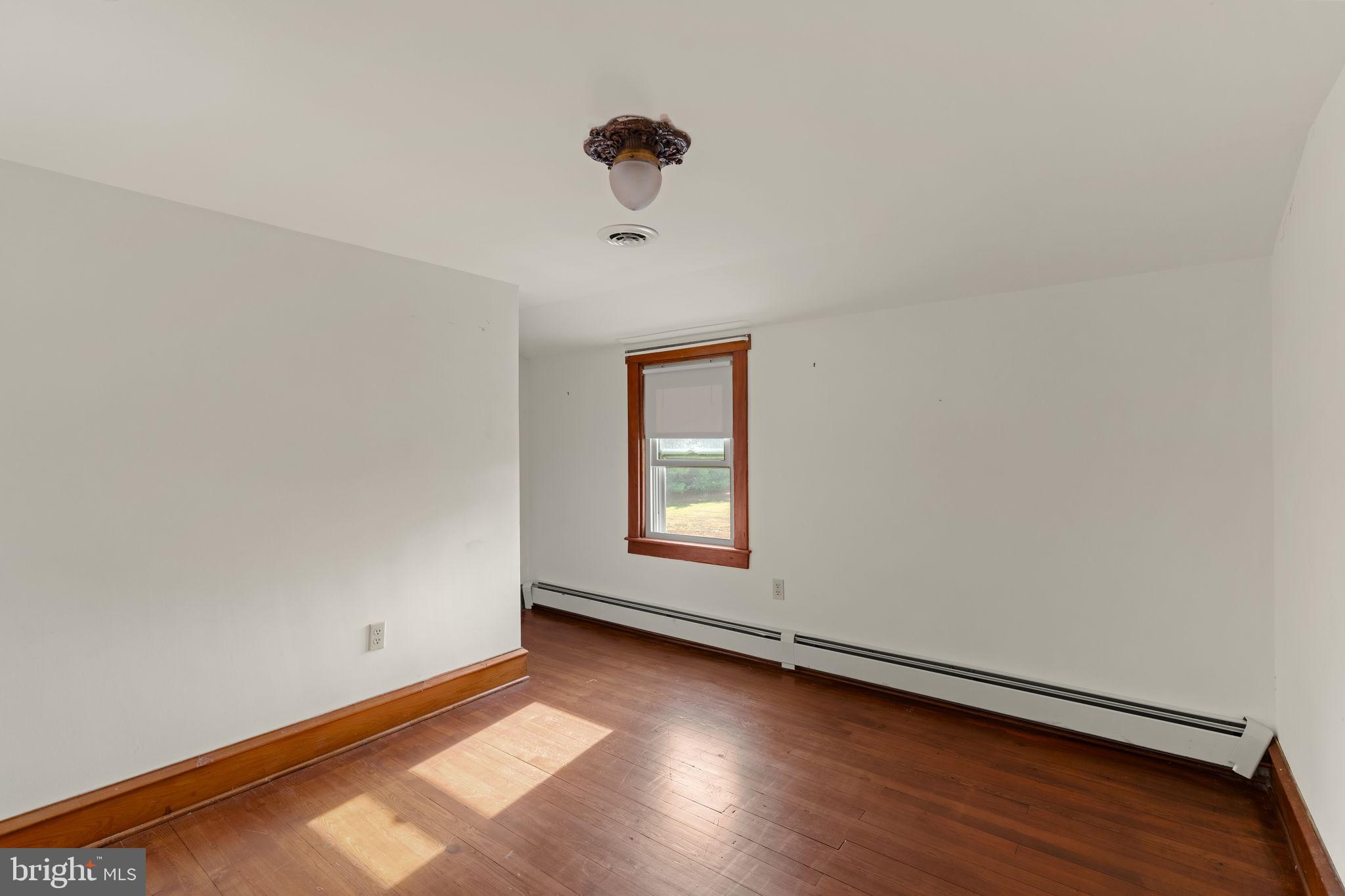 451 Pine Swamp Road Elverson, PA 19520 - Photo 34 of 91 an empty room with wooden floor and windows