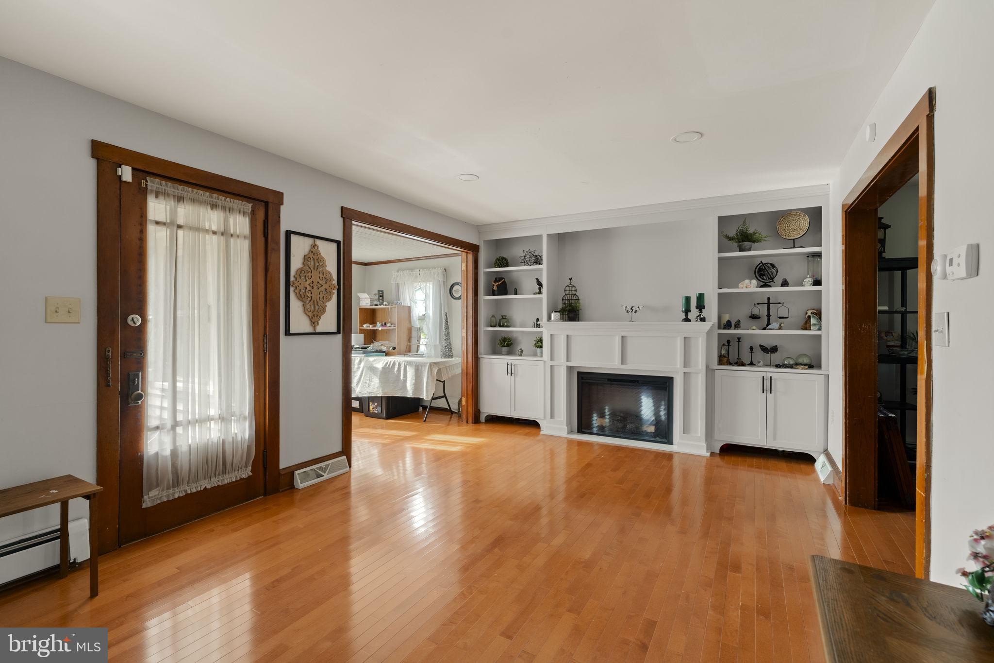 451 Pine Swamp Road Elverson, PA 19520 - Photo 5 of 91 a view of a livingroom with a fireplace wooden floor and window