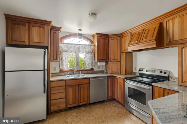a kitchen with stainless steel appliances granite countertop a refrigerator and a sink