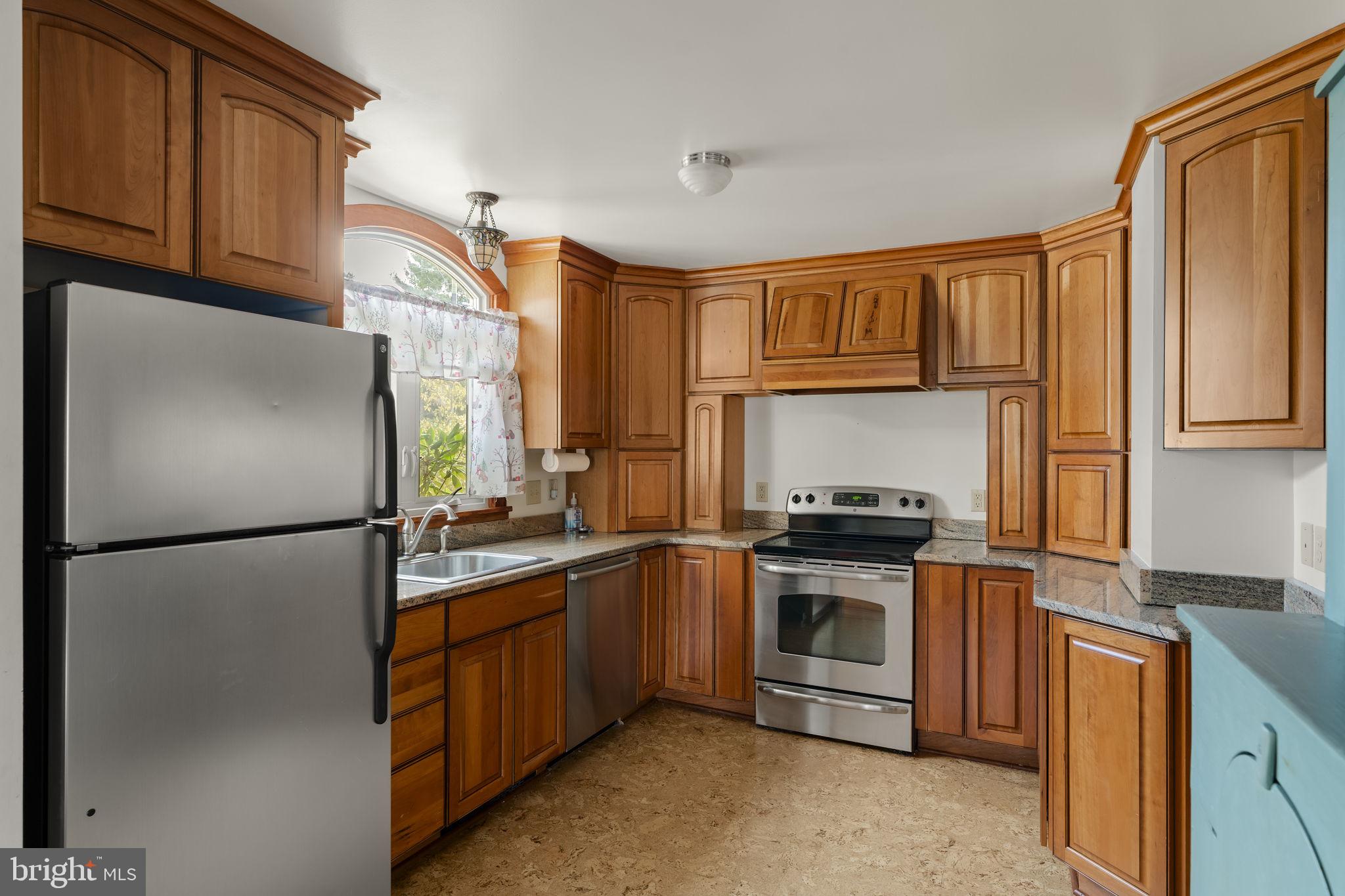 451 Pine Swamp Road Elverson, PA 19520 - Photo 10 of 91 a kitchen with stainless steel appliances granite countertop a refrigerator a stove a sink and a microwave