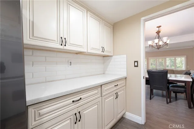 a kitchen with white cabinets and window