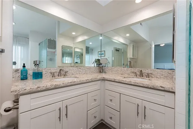 a bathroom with a granite countertop sink double and mirror