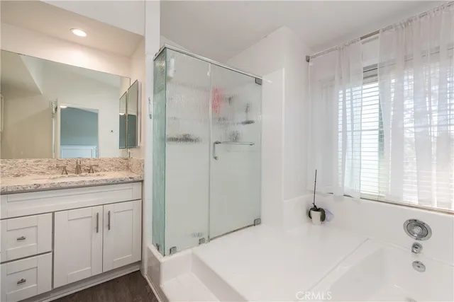 a bathroom with a granite countertop sink a mirror and a bathtub