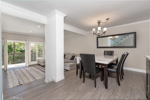 a view of a dining room with furniture a chandelier and wooden floor