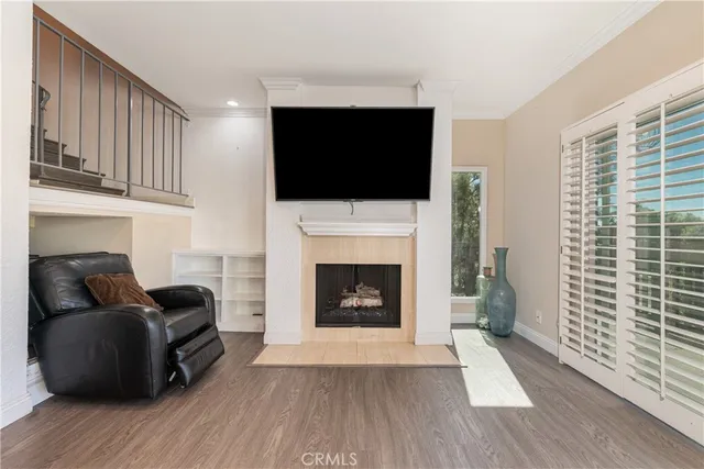 a living room with furniture a flat screen tv and a fireplace