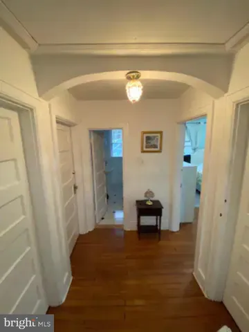 a view of a bedroom with wooden floor and furniture