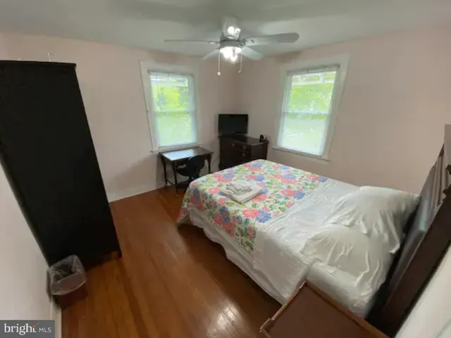 a bedroom with a bed tv and a window