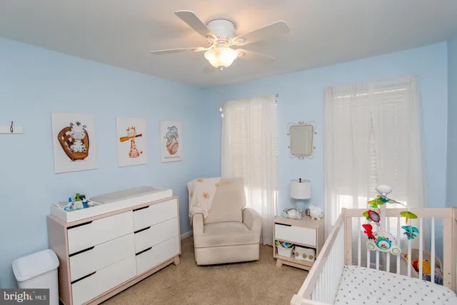a bedroom with furniture and a chandelier fan