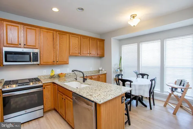 a kitchen with granite countertop a stove a sink and a refrigerator