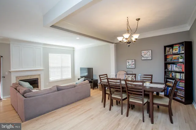 a living room with furniture a chandelier and a fireplace