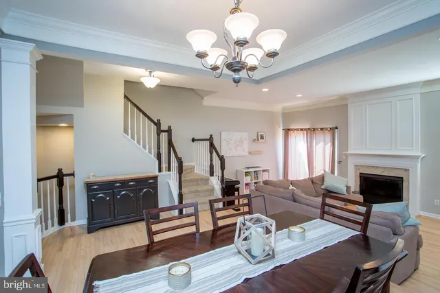 a living room with furniture chandelier and a fireplace