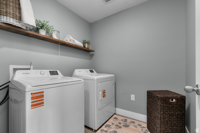 2819 South 710th West, Unit 14 Logan, UT 84321 - Photo 20 of 24 Dedicated laundry space featuring a white top-load washer and dryer set, a floating wood shelf, light gray walls, and white baseboards
