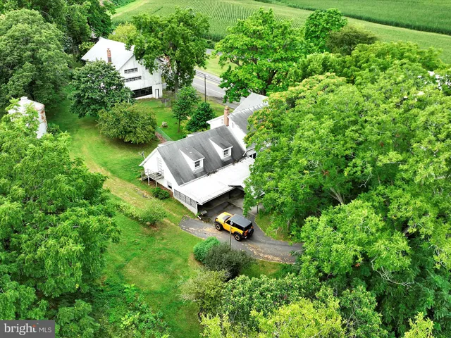 a view of a lush green forest with houses a lake and mountain view