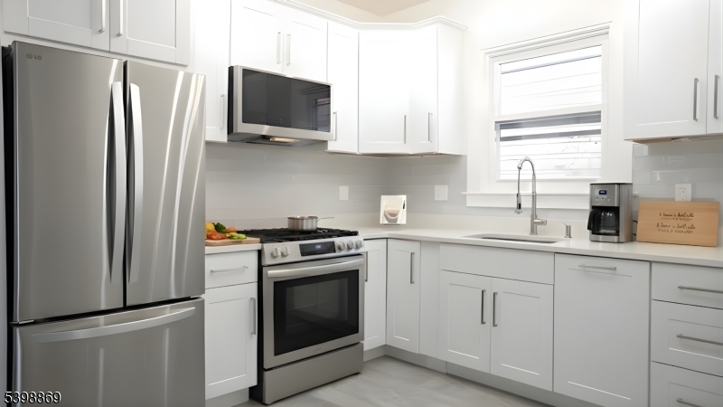 65 Poe Avenue Newark, NJ 07106 - Photo 14 of 18 a kitchen with white cabinets stainless steel appliances and sink